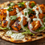 A photo of chicken tikka flatbreads with a drizzle of minted yoghurt.
