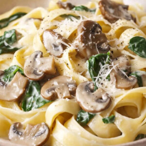 A photo showing a bowl of creamy mushroom tagliatelle with spinach.